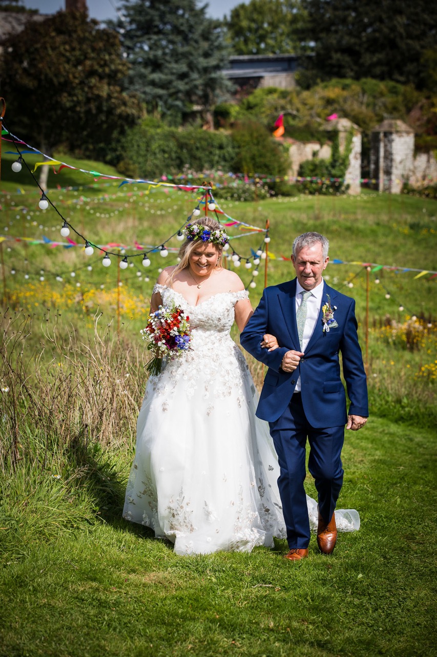 father walking bride down the aisle at outdoor festival wedding