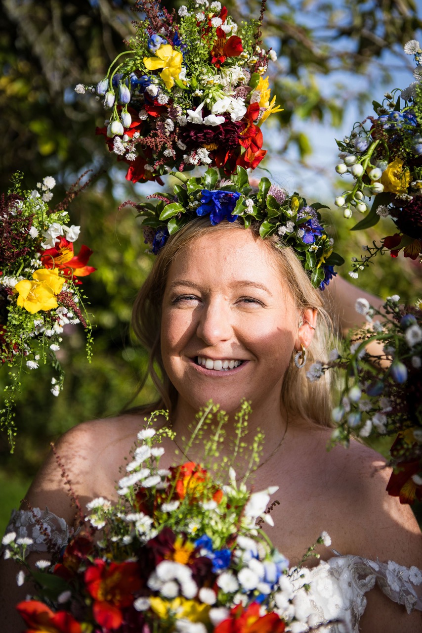 bride wearing a flower crown and surrounded by her bridesmaids bouquets