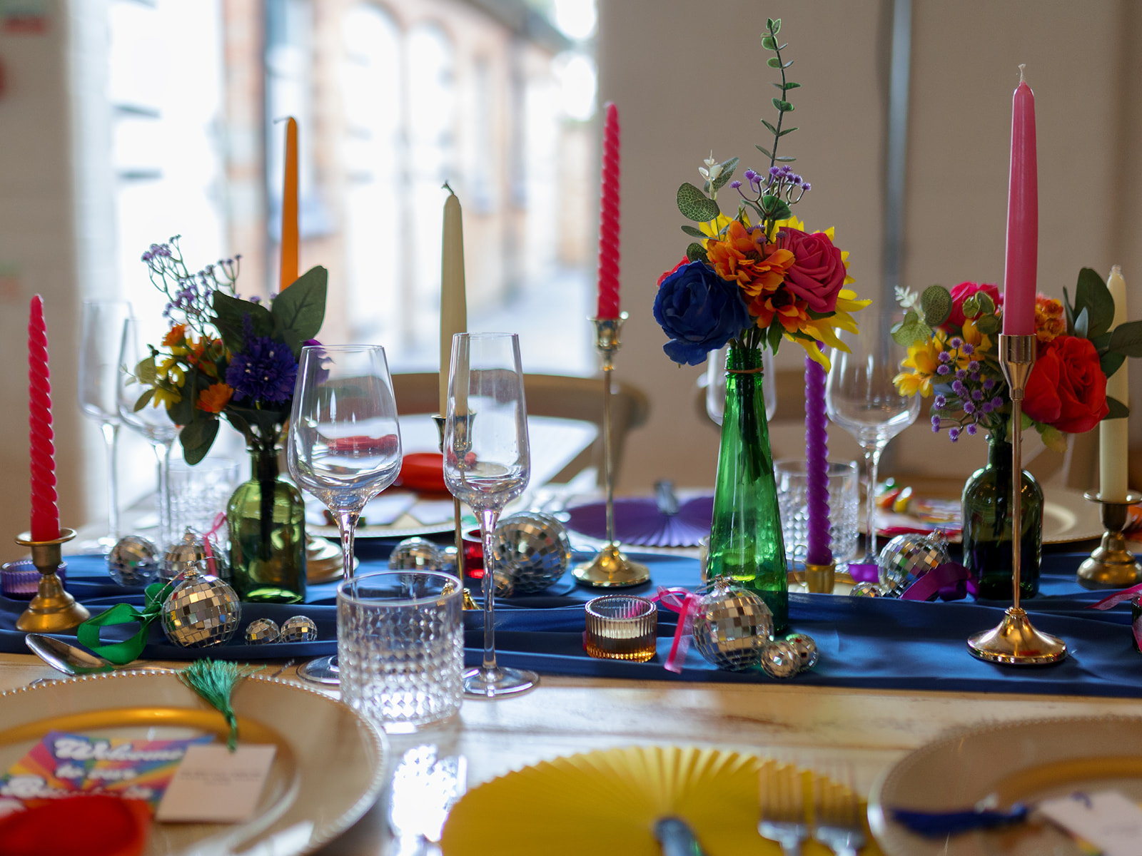 rainbow wedding flowers and candles for colourful wedding
