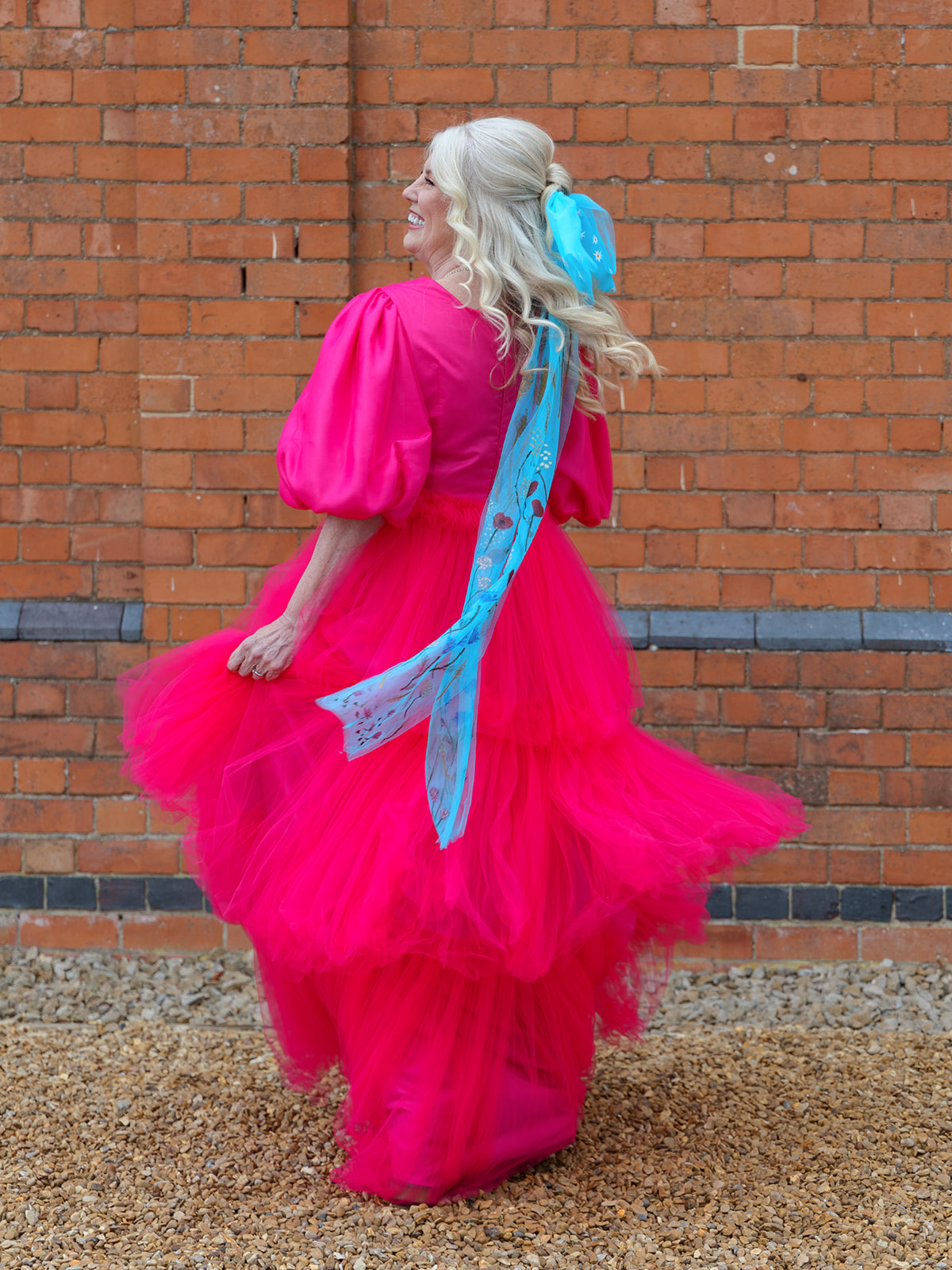 mature bride wearing bright pink wedding dress and blue hair bow
