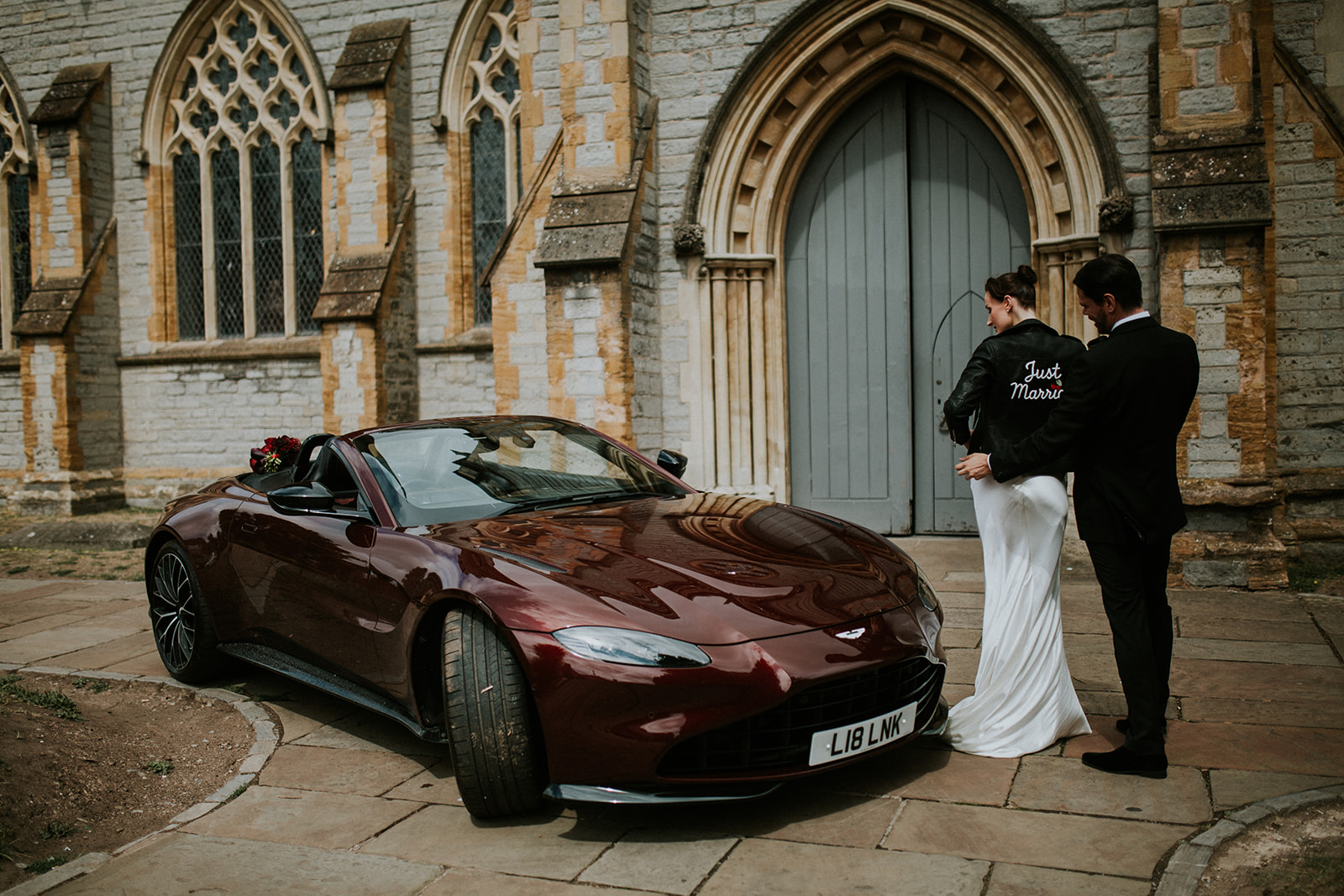 deep red wedding car parked outside of the church for cherry red winter wedding
