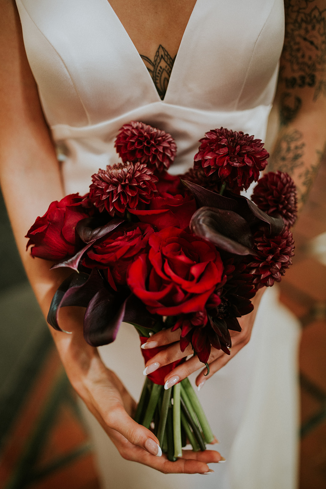 detail shot of deep cherry red wedding bouquet with calla lilies and roses