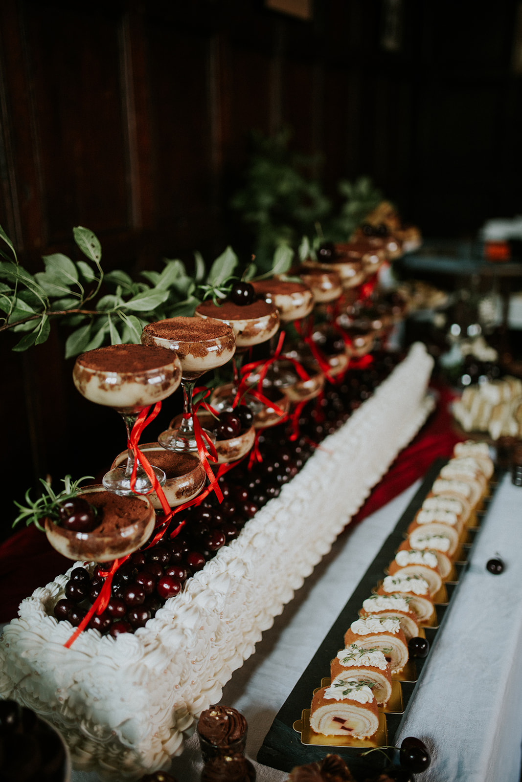 detail shot of champagne glasses containing tiramisu stacked on top of a cake as part of an alternative wedding breakfast desert table