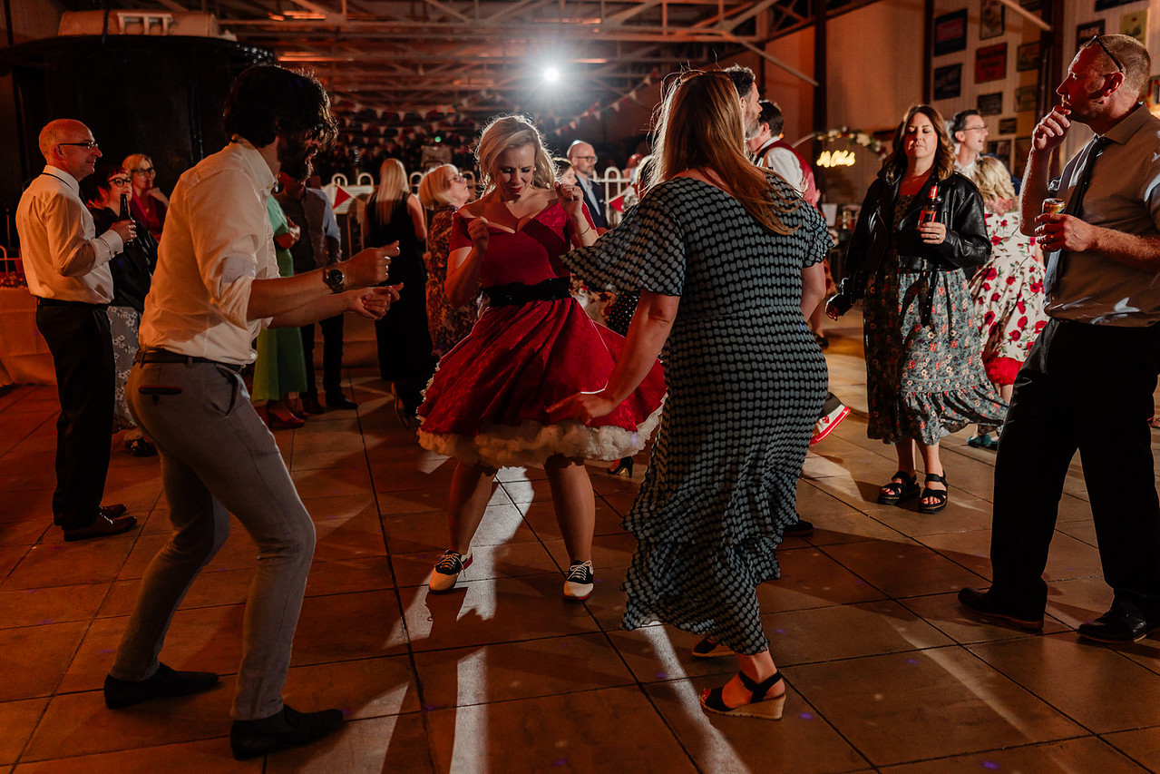 bride wearing 1950s rock and roll dress dancing with wedding guests
