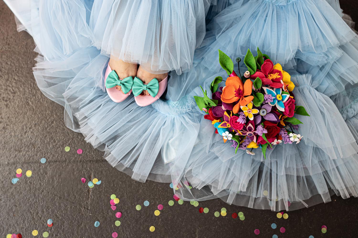 Boom Bridal colourful alternative wedding bouquet captured on top of a pale blue wedding skirt with matching shoes