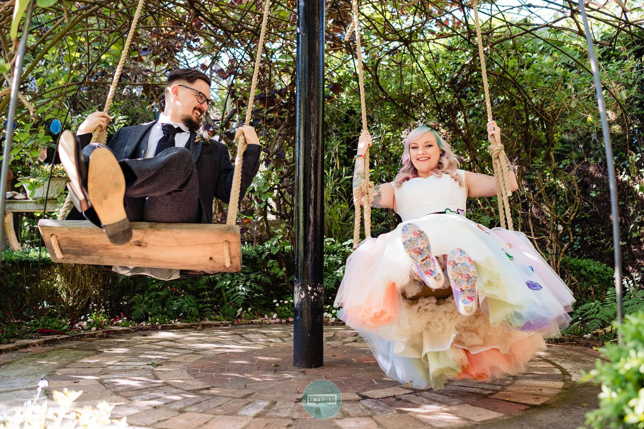 rainbow wedding themed wedding dress by the little wedding shop - colourful wedding inspiration - couple on swings - rainbow tulle layers - bespoke wedding dress inspiration with dice and irregular choice shoes