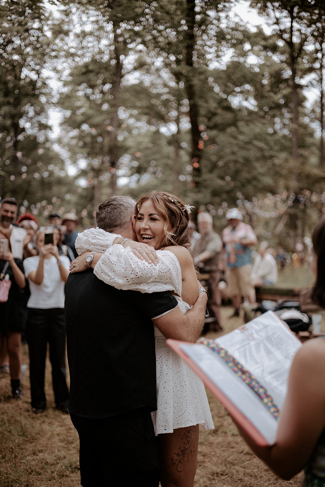 Bride and groom hugging during their outdoor ceremony in a wood