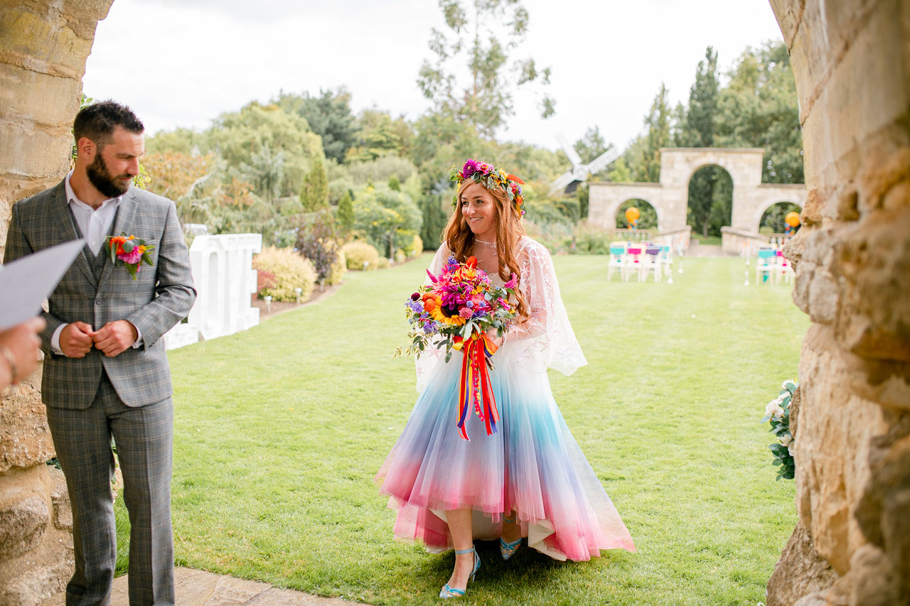 outdoor rainbow wedding - colourful wedding ceremony - colourful wedding flowers - ombre wedding dress