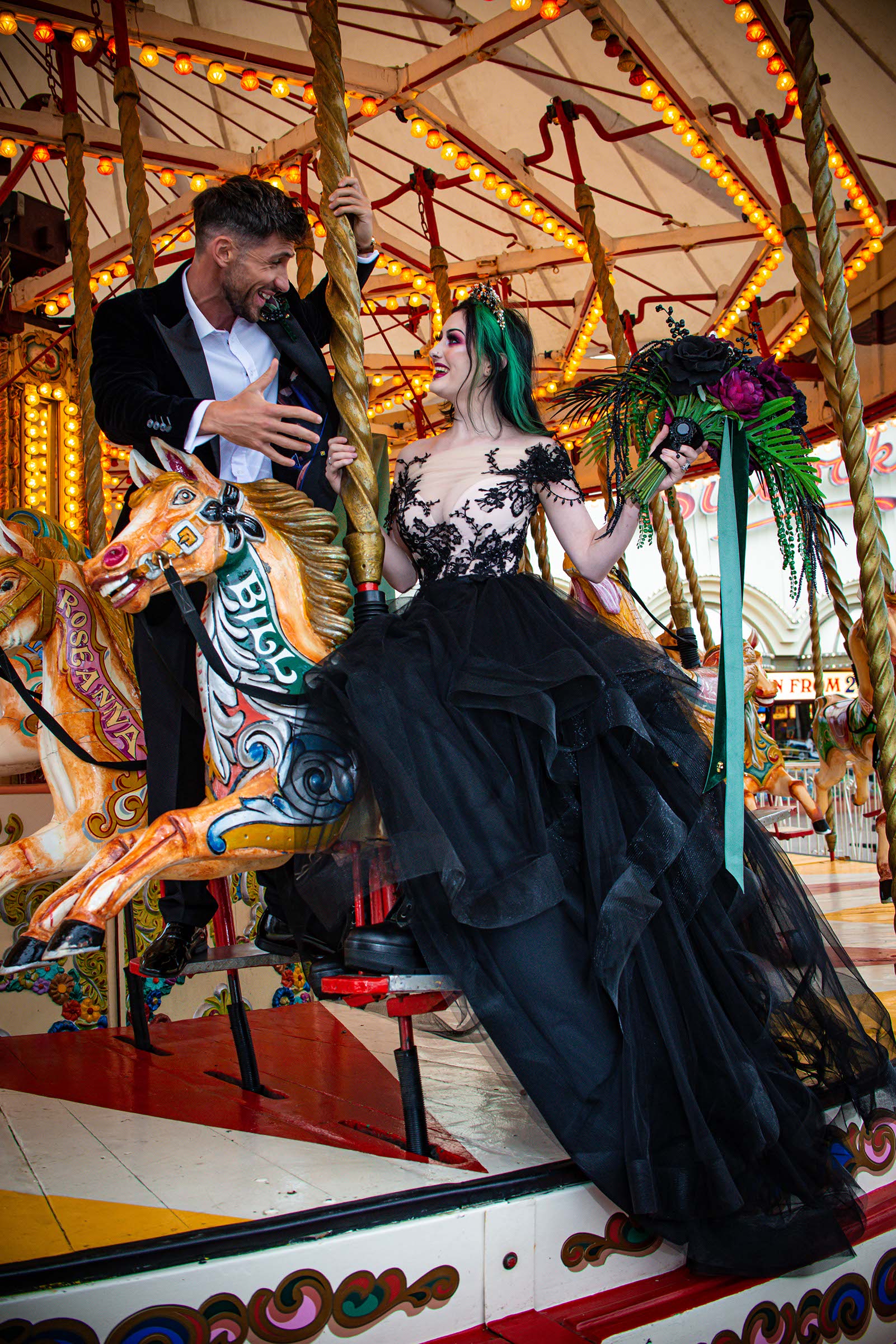 alternative luxe wedding - slytherin wedding - gothic wedding - alternative wedding - fun wedding ideas - bride and groom on carousel