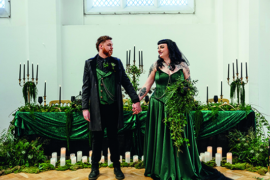 Alternative couple get married. bride wears dark emerald green wedding dress