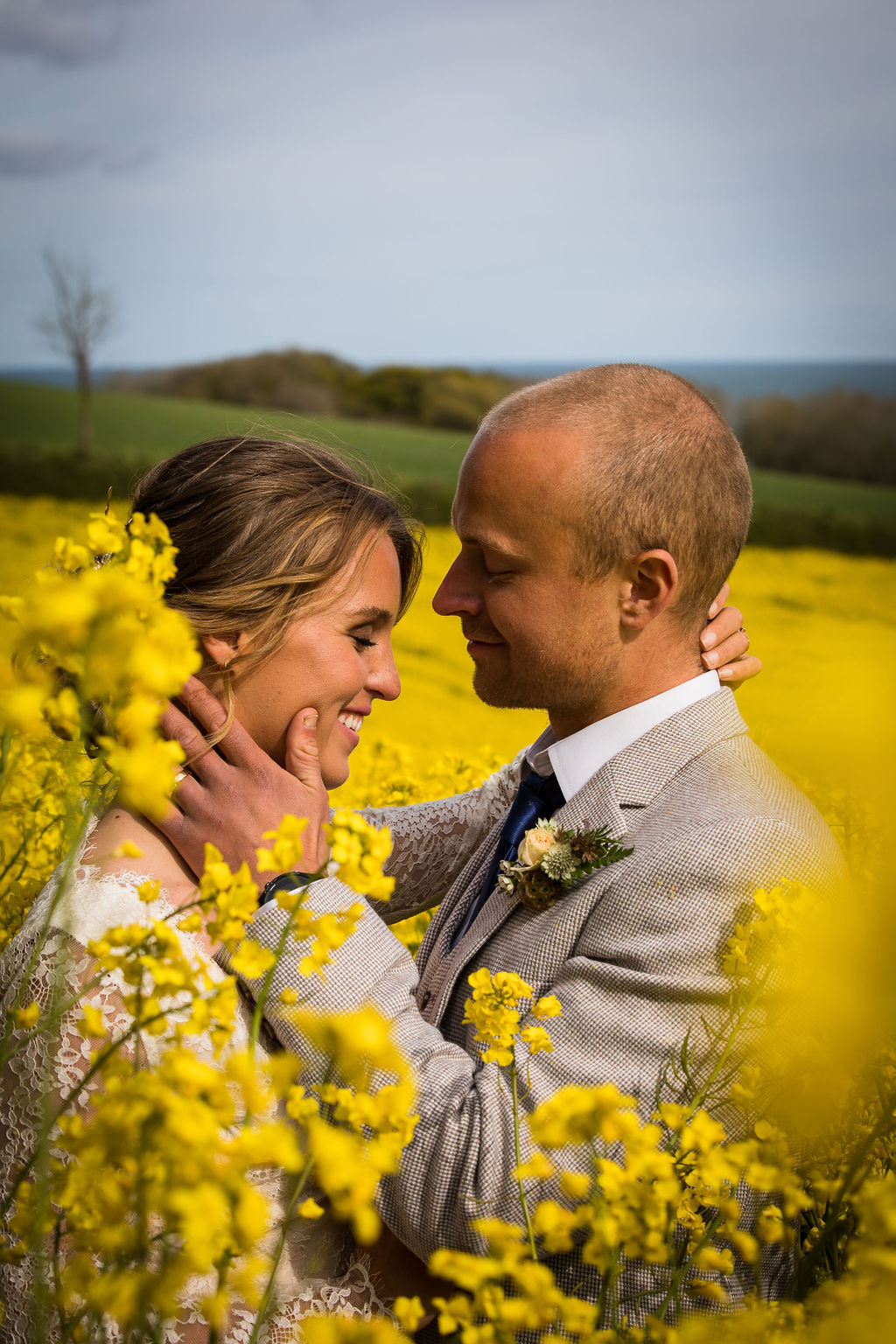 bride and groom in field of yellow flowers