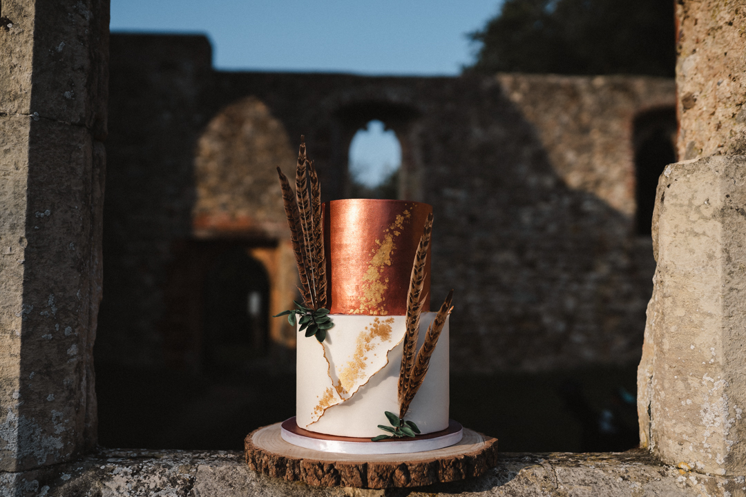 autumn elopement wedding cake with gold detailing and peacock feathers