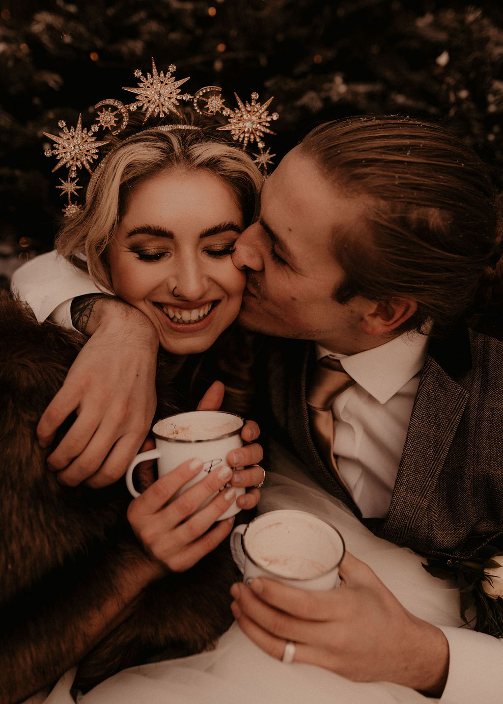 Elegant winter wedding inspiration in the snow - elopement wedding - couple embracing with hot chocolate in hand