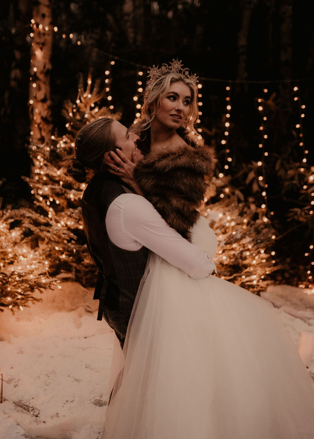 elegant winter wedding -couple dancing in the snow with sparkley fairy lights 3