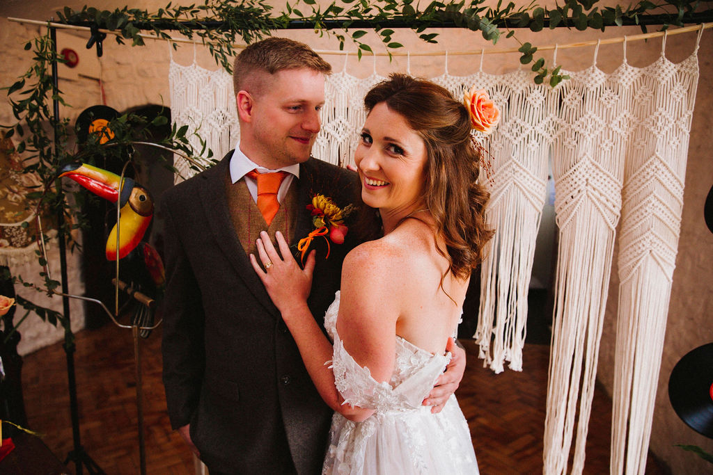 bride and groom against macrame backdrop - bold autumn wedding