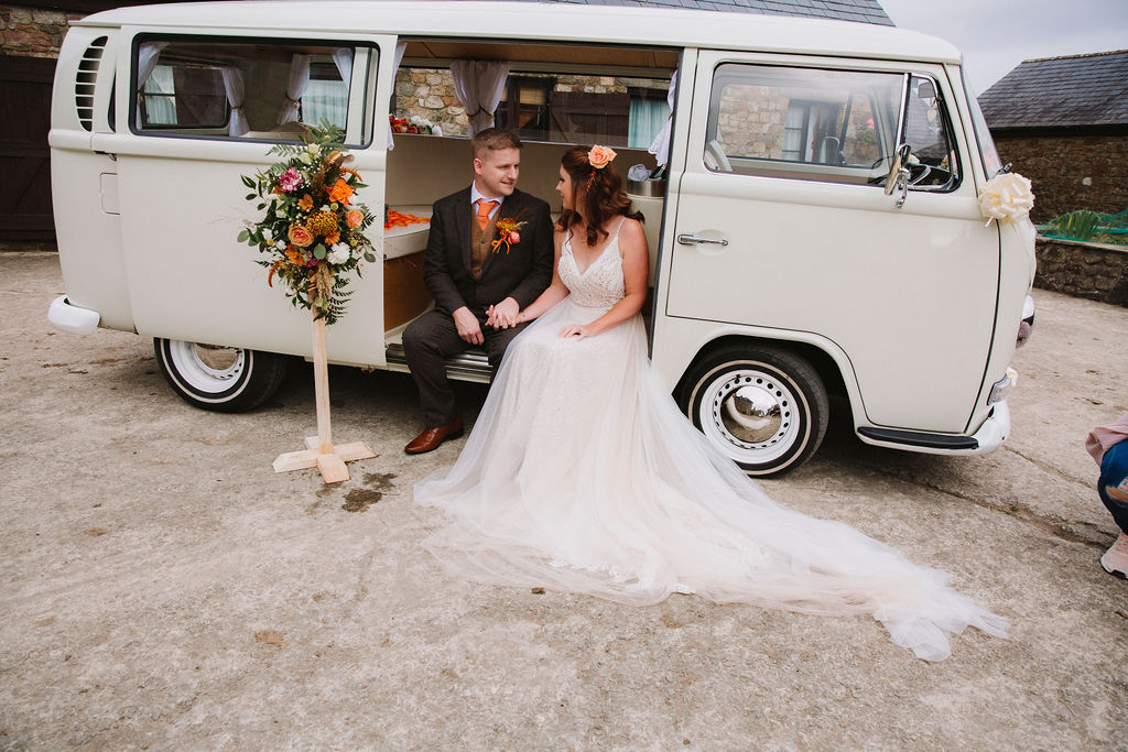 bride and groom sitting in camper van - unique wedding transport