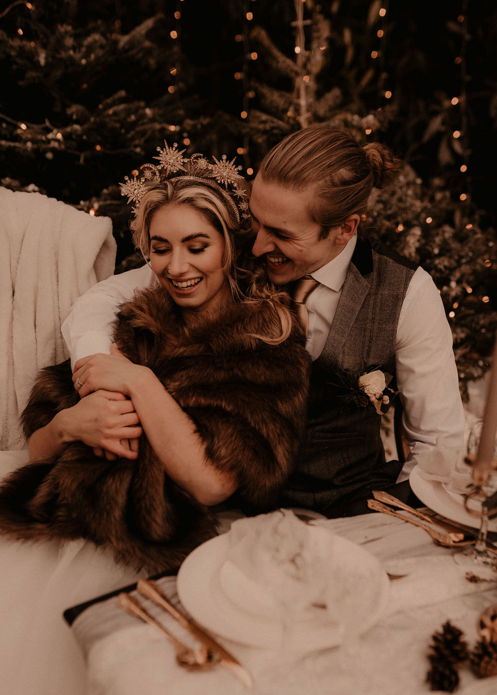 Elegant winter wedding inspiration in the snow - elopement wedding - couple embracing with fur throws in the snow