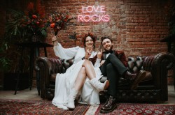 newlyweds sat together on a black leather sofa at the shack revolution industrial wedding venue in hereford
