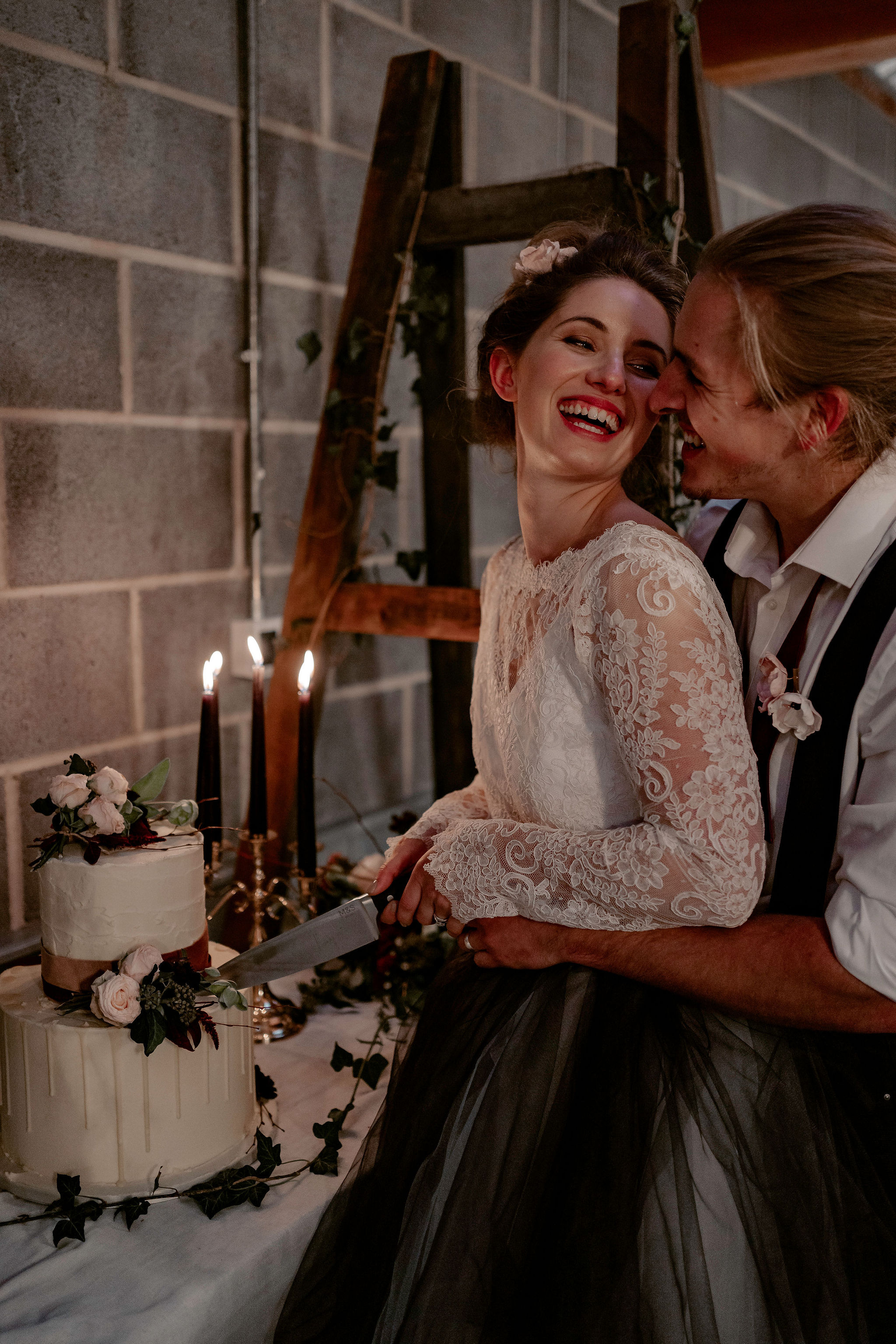 bride and groom cutting cake and laughing - micro wedding inspiration