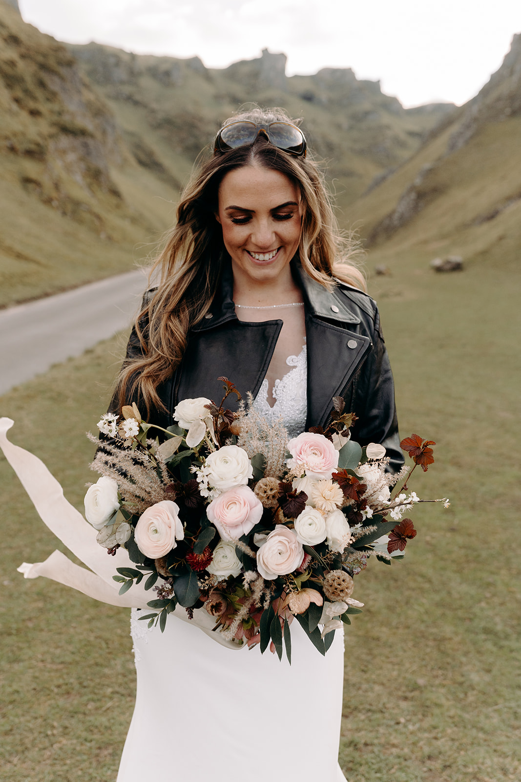 peak district wedding - bride in leather jacket holding bouquet