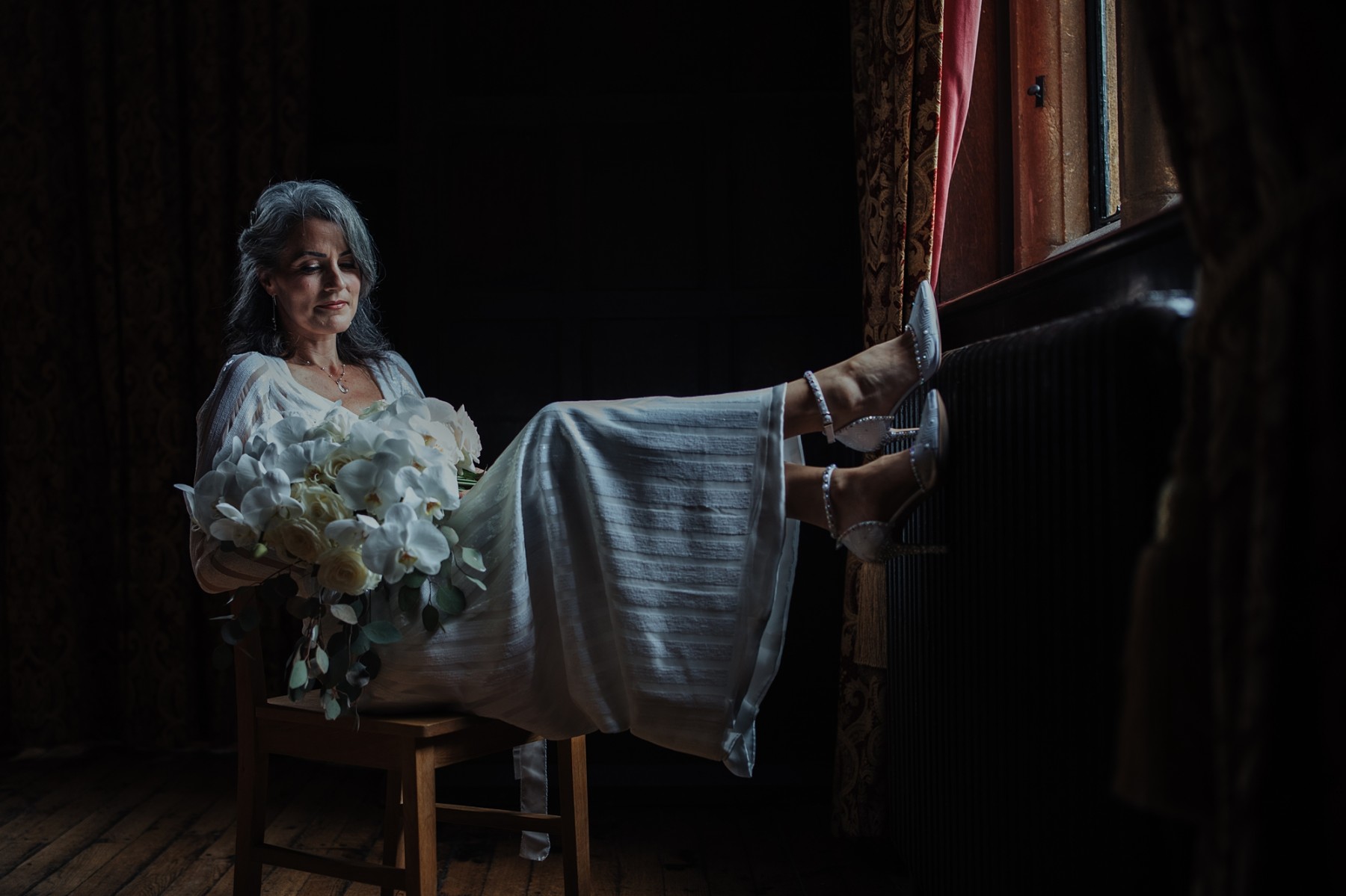 mature bride wearing an art deco wedding dress, holding a white bouquet
