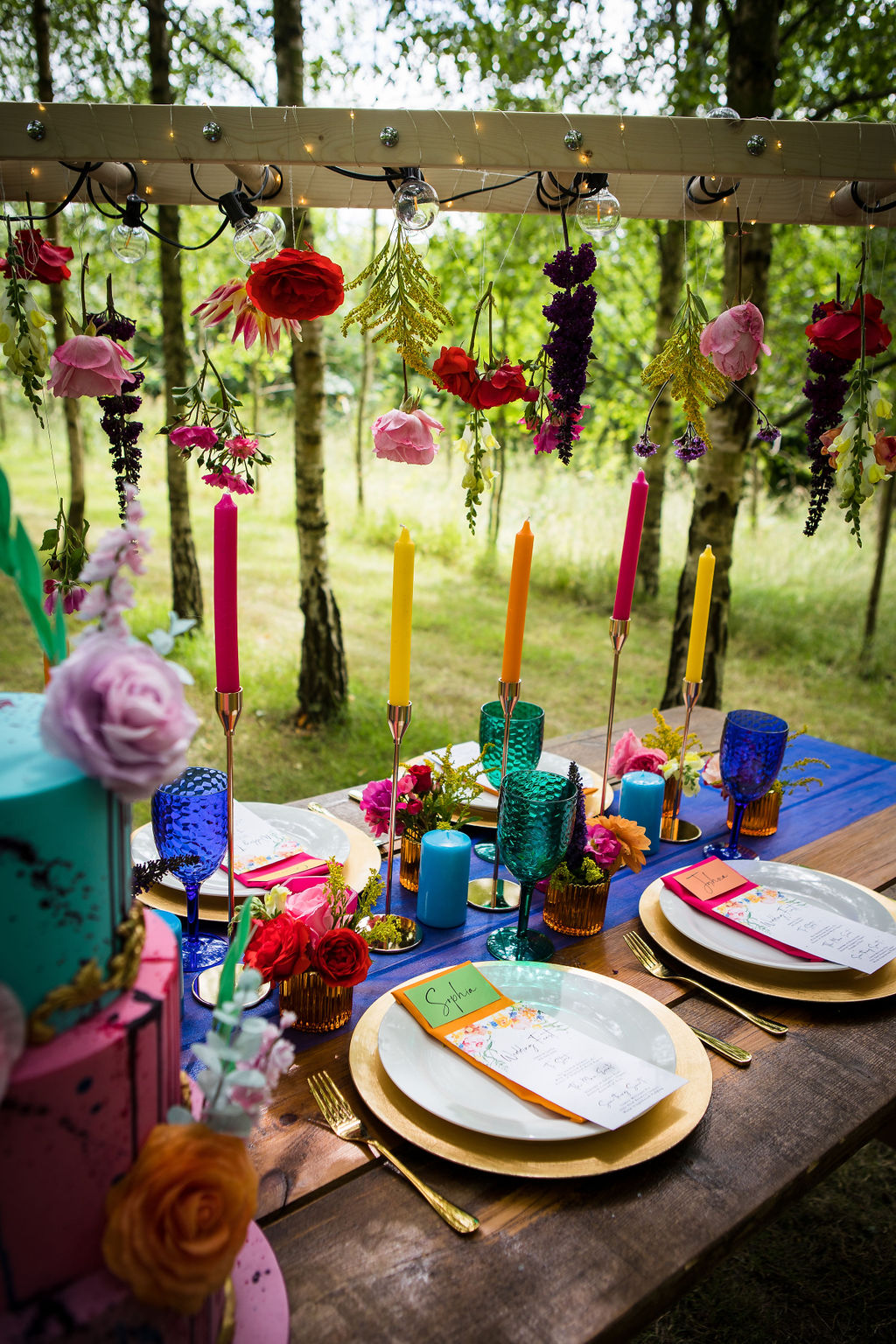 colourful outdoor tablescape with eclectic candles and glassware