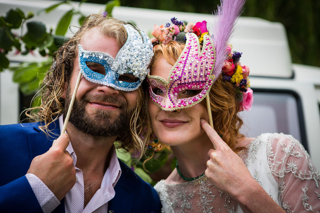 bride and groom with masks on for photobooth