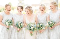 Bride and her bridesmaids stood holding their bouquets of flowers. Bridesmaids wear white dresses