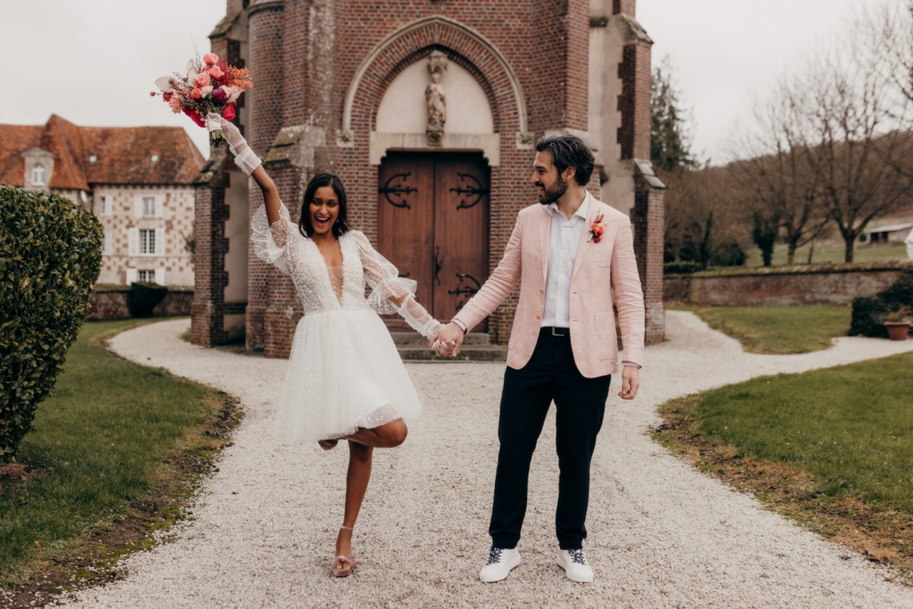 retro red and pink wedding ideas - groom in pink blazer and bride in short pearl wedding dress