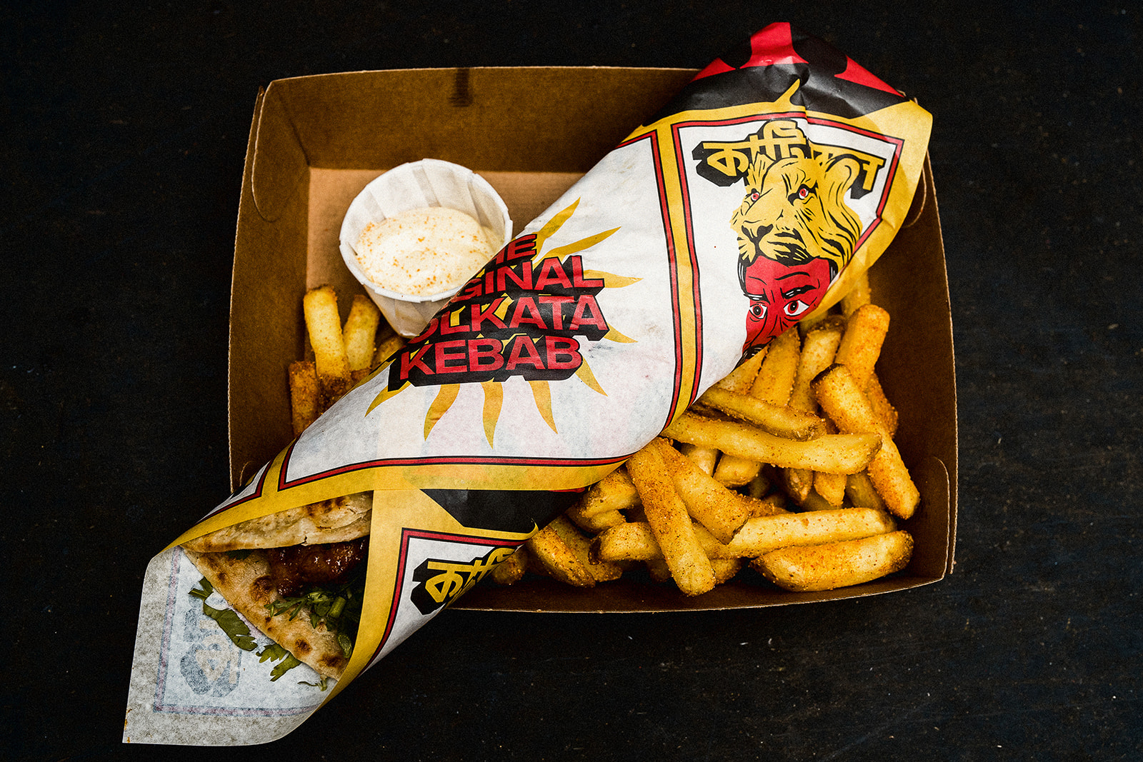 A flat lay shot of a kebab and chips. Kebab is wrapped in comic book style paper. Food supplied by Chew That! London wedding caterers.