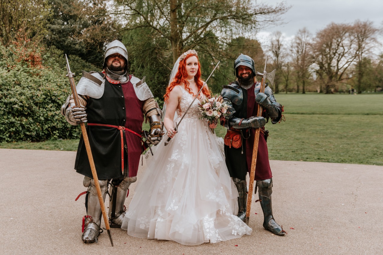 bride holding a sword with a knight on each side of her - fantasy wedding ideas
