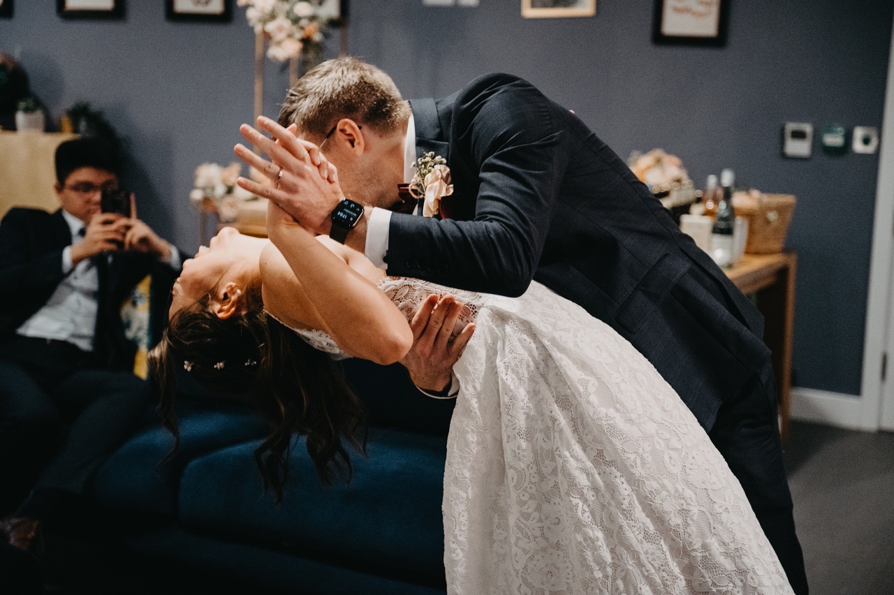 groom dipping bride during small wedding first dance