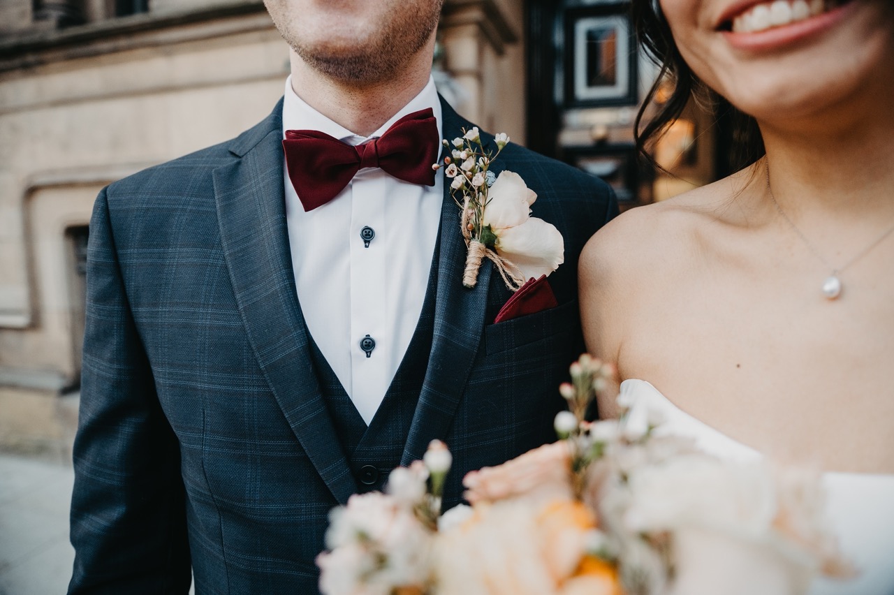 groom wearing subtle tweed suit with a burgundy velvet bowtie - groomswear inspiration
