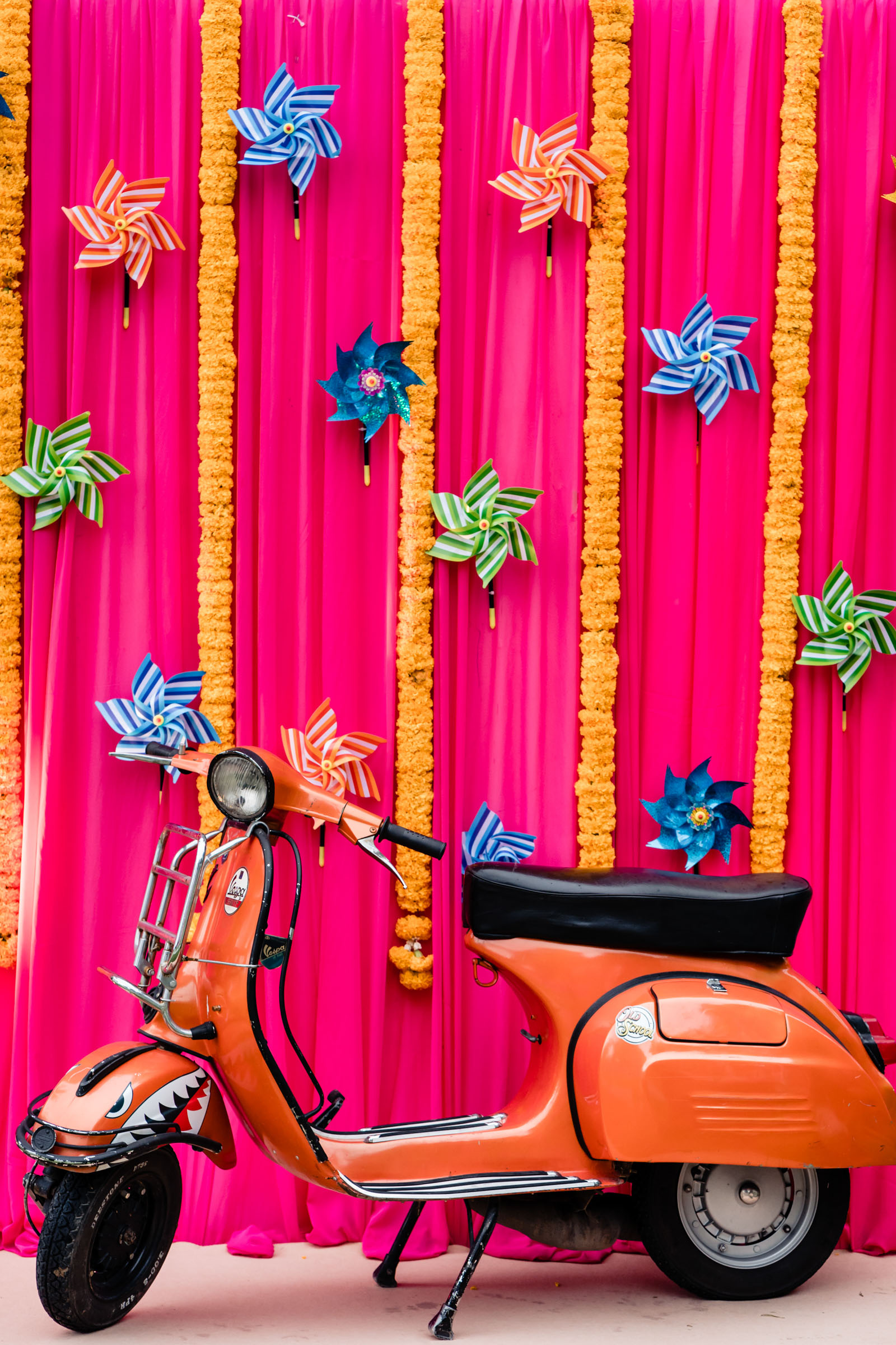 orange motorbike against a bright pink colourful backdrop