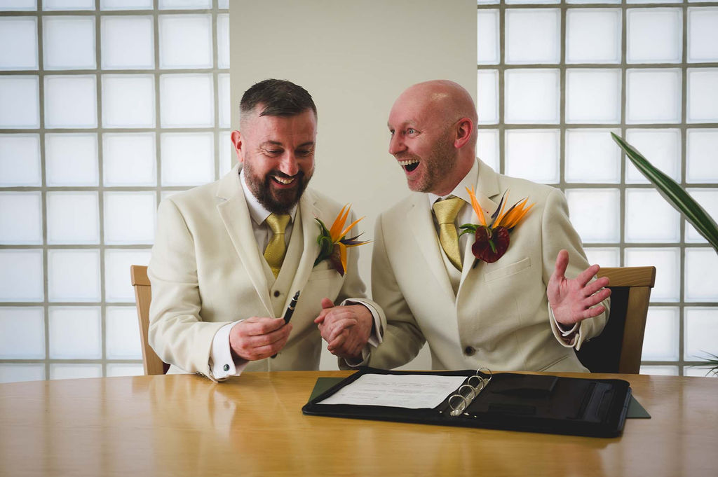 two grooms signing their wedding papers at the old library in birmingham