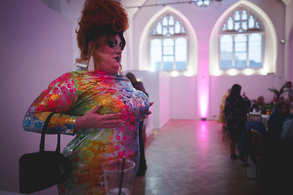drag queen wedding performer wearing a rainbow dress