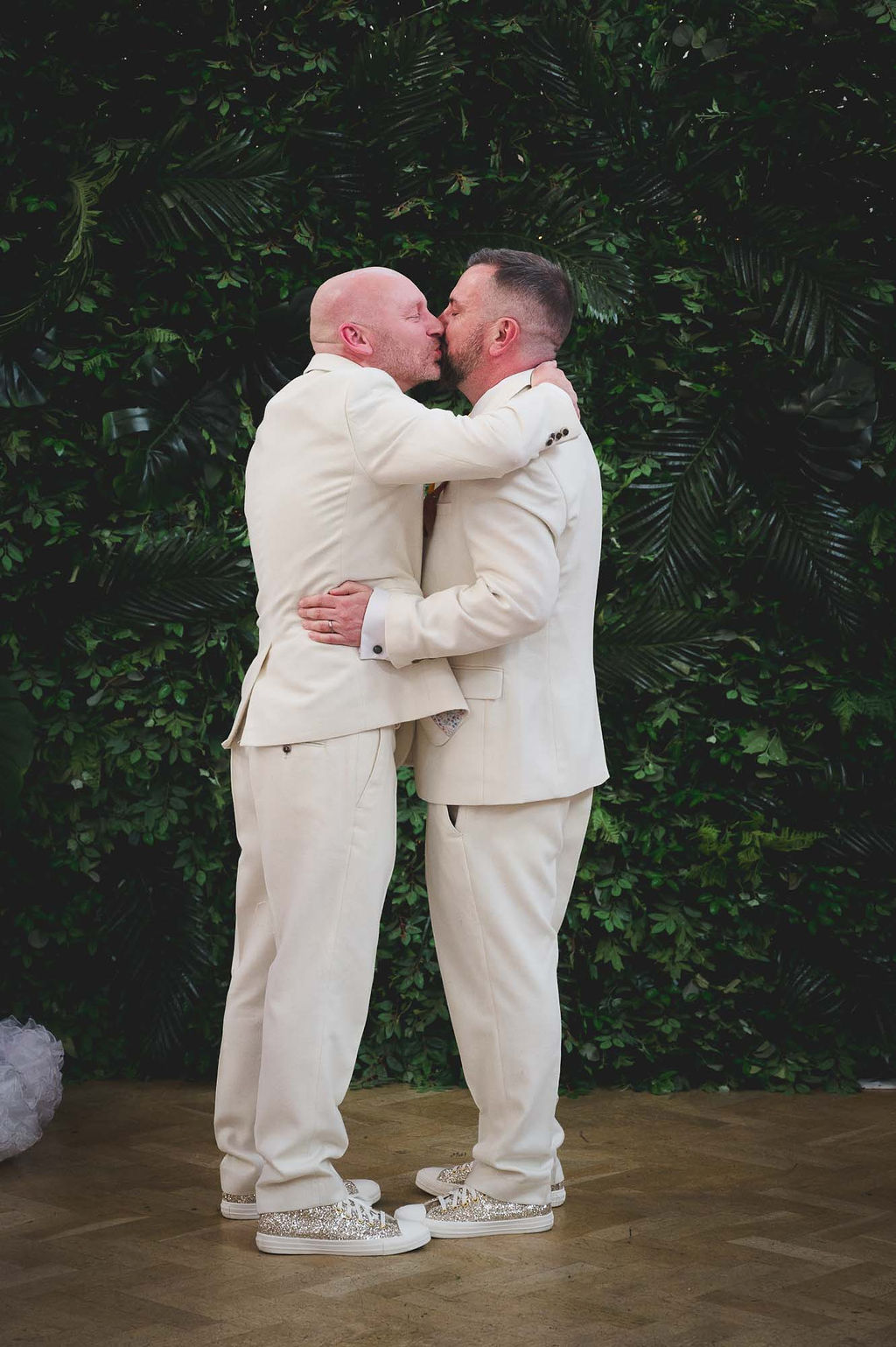 two grooms kissing in their wedding ceremony