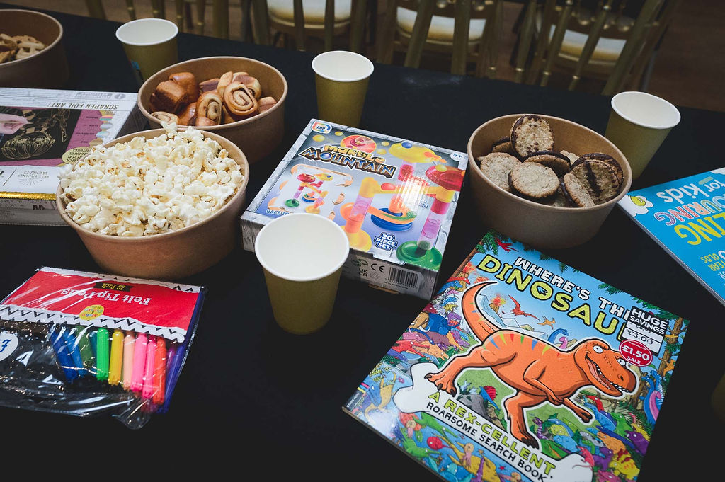 Kids table at a wedding with snacks and games