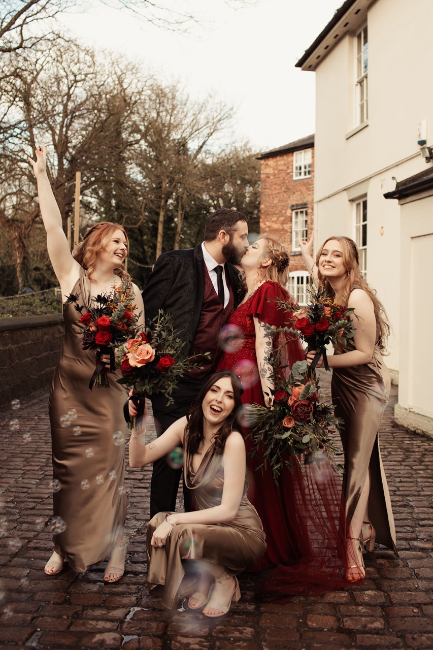 fun photo of bride and groom with bridesmaids striking poses