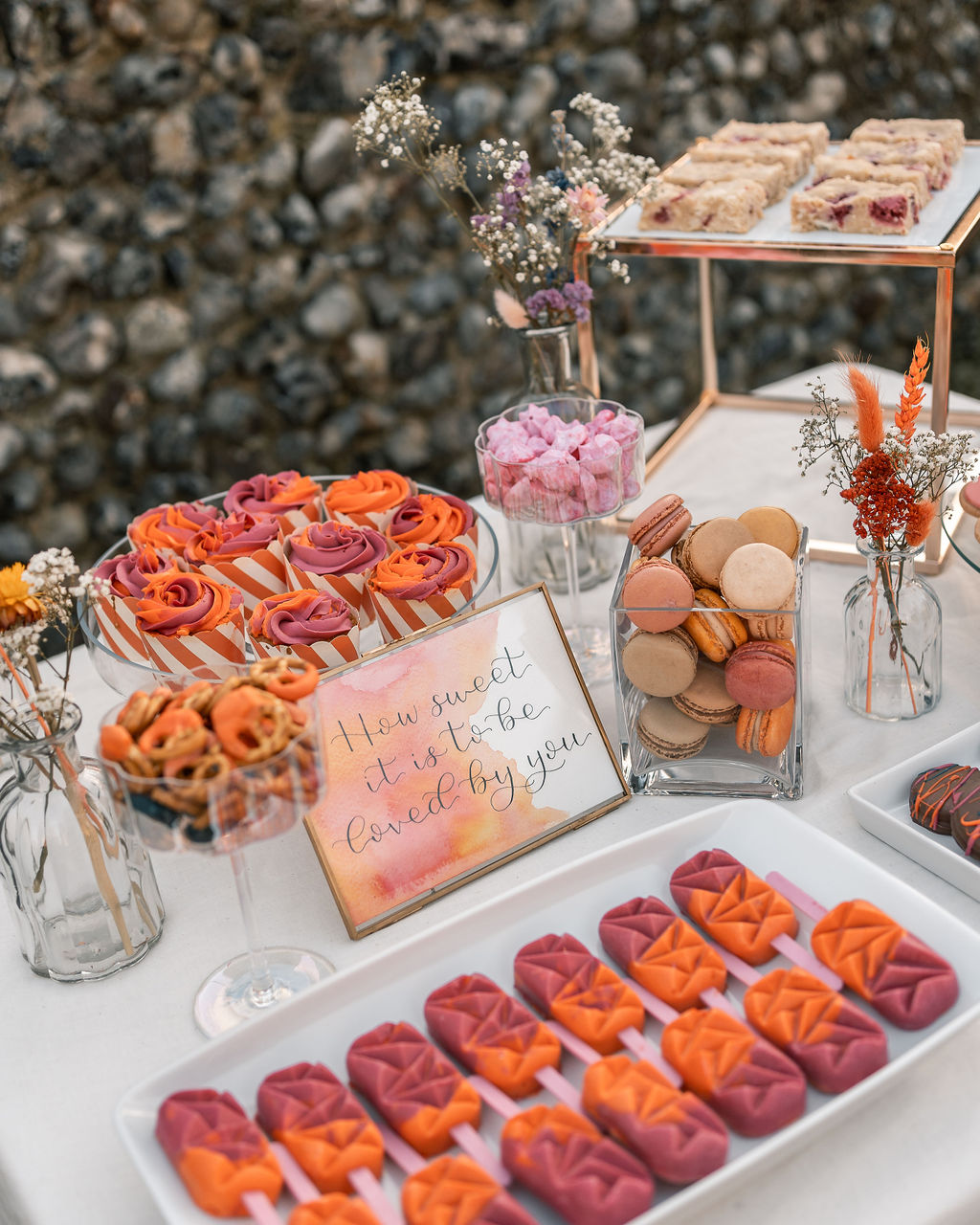 pink and orange wedding cakes and macarons