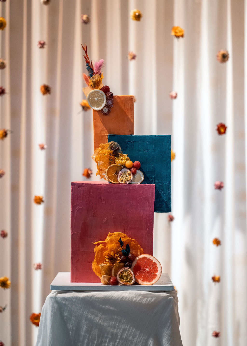 geometric three tier wedding cake with pink, orange and blue tiers
