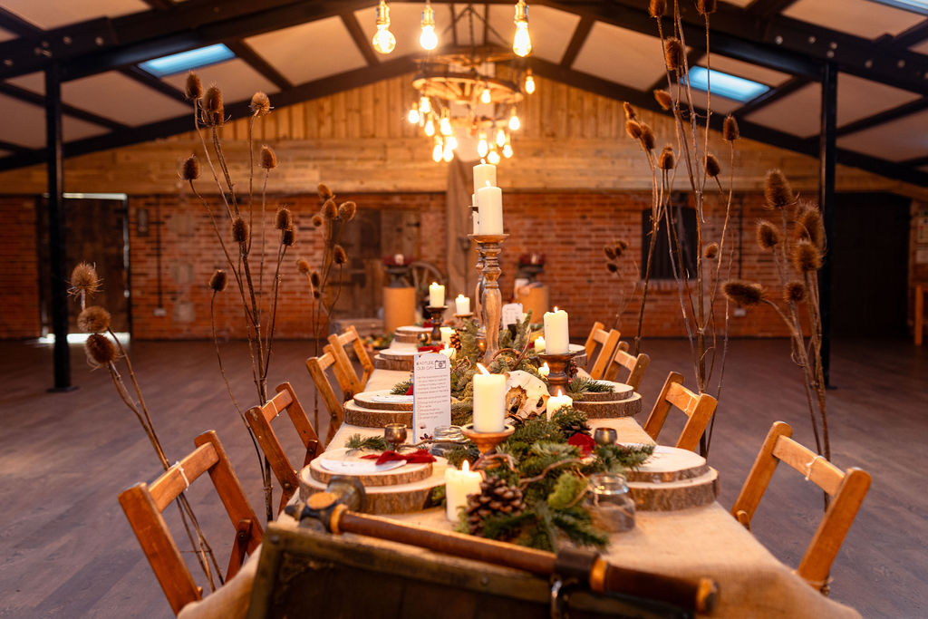 winter wedding inspired wedding stationery and table dressing. Blue spruce, chunky candles, pine cones, wooden log slices and hessian decorate the long trestle table