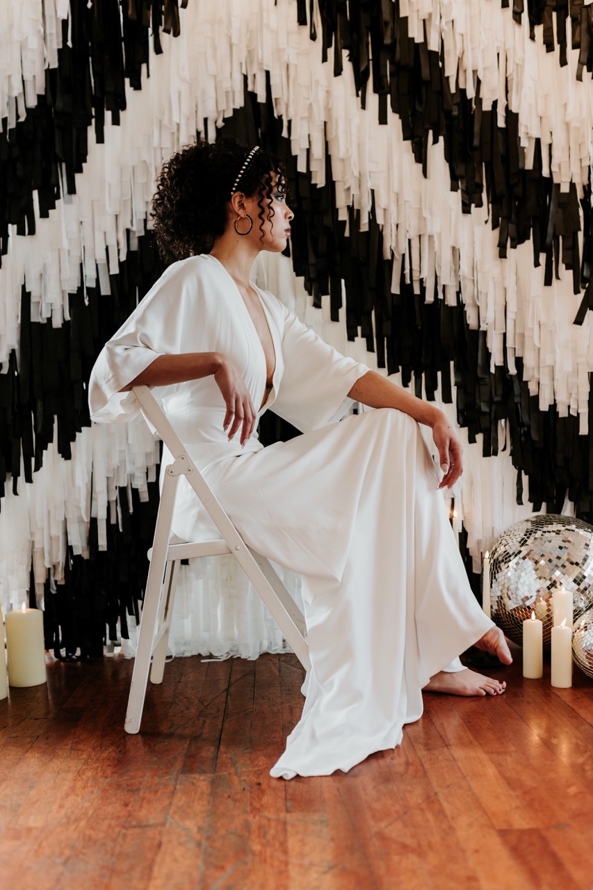 bride sat in front of black and white tassel wedding backdrop