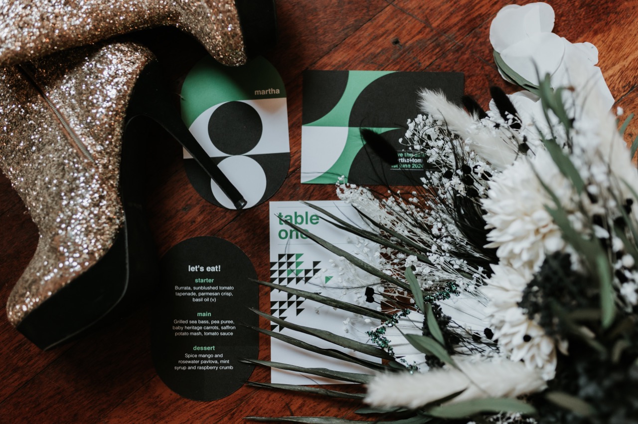 black white and green wedding styling flat lay