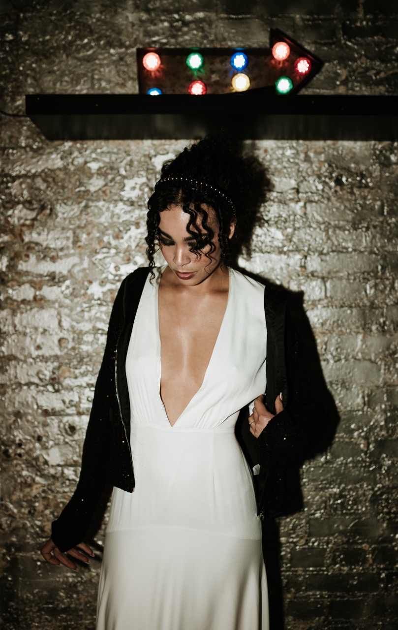 bride wearing low cut wedding dress with black sparkly jacket