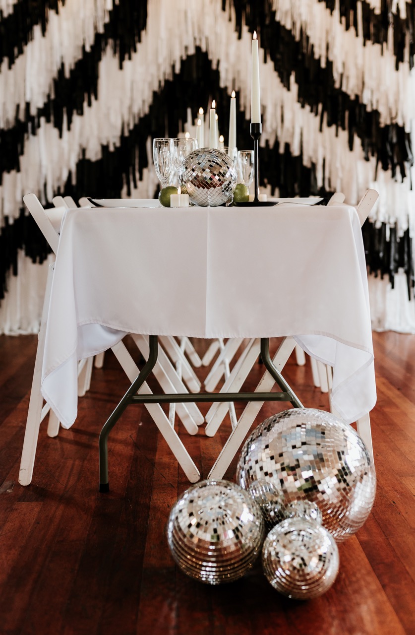 black and white wedding styling with tassel backdrop and disco balls