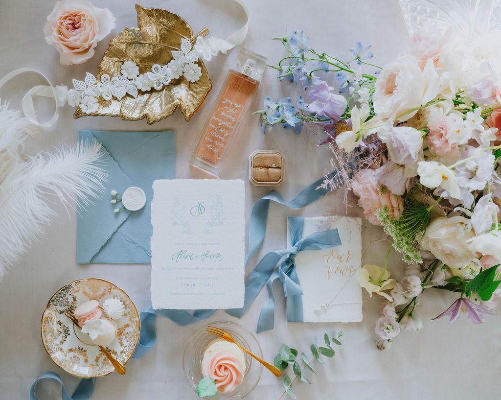 pastel wedding flat lay with bouquet, stationery, jewellery and perfume