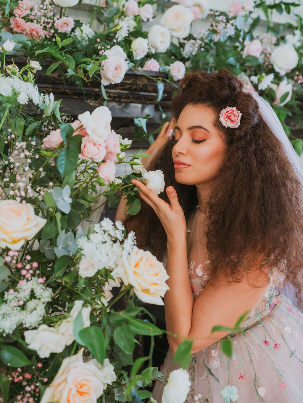 bride surrounded by whimsical pastel coloured wedding flowers