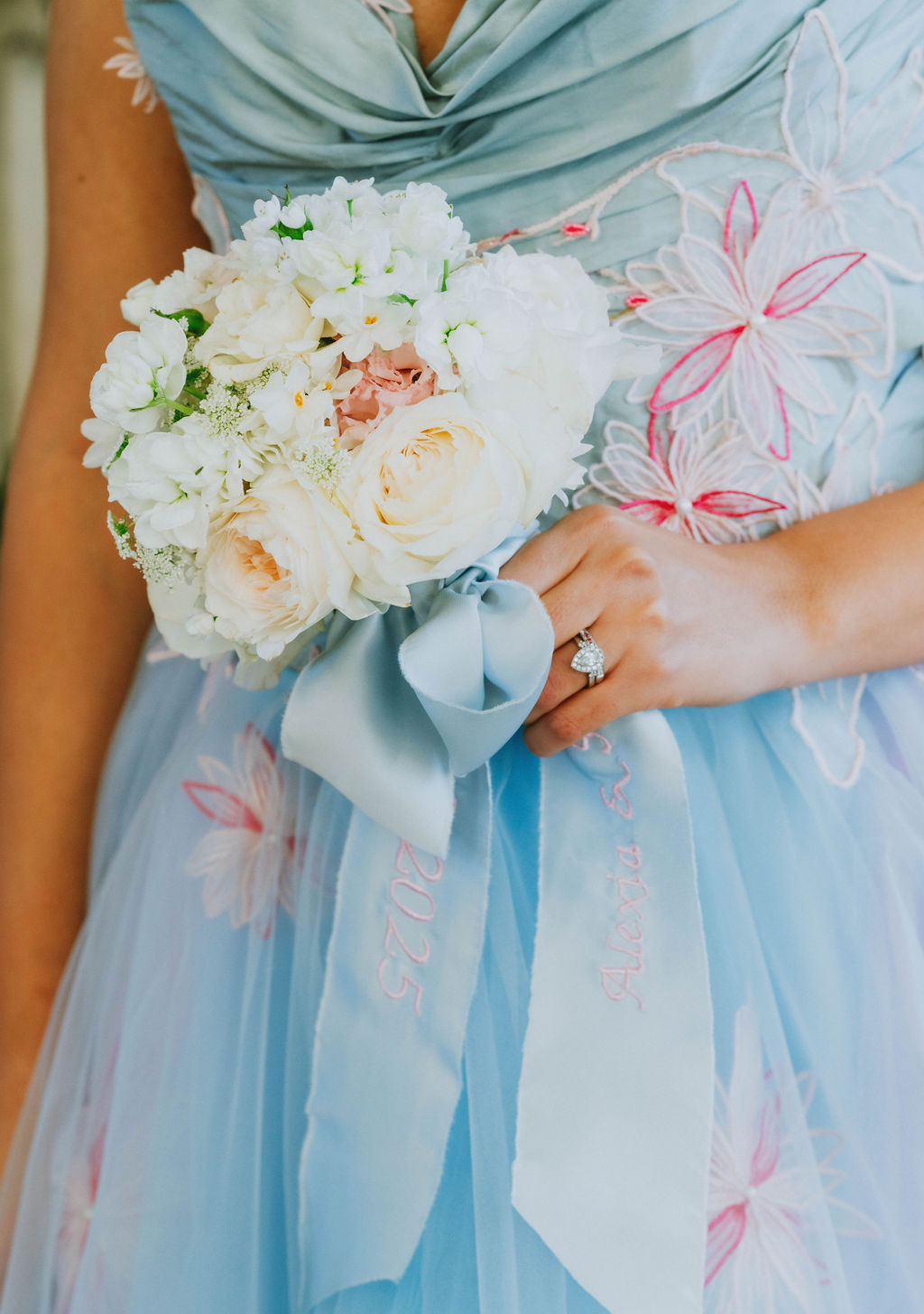 small white bouquet against pastel blue wedding dress