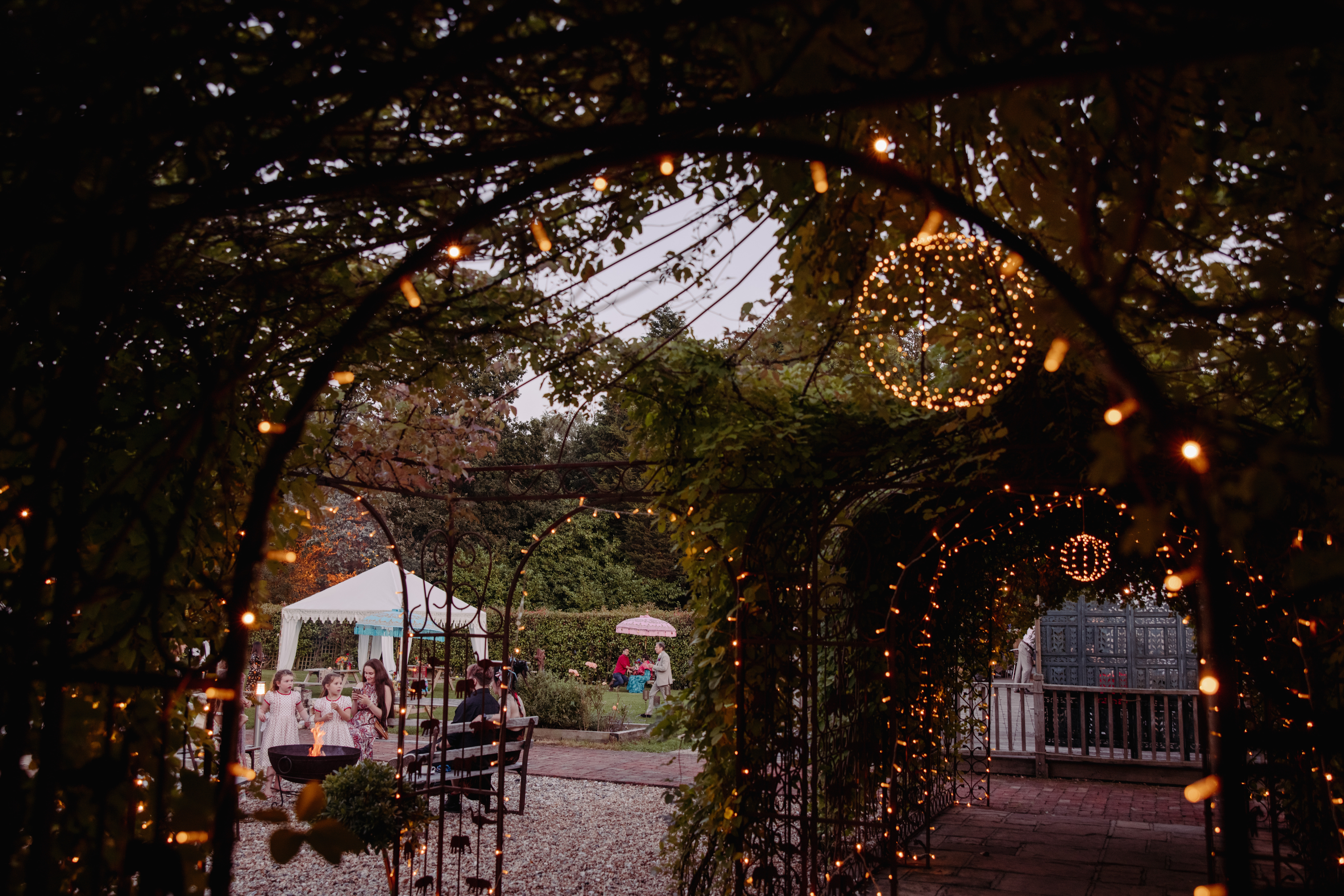 a picture of the outdoor space at trading boundaries wedding venue in east sussex. Courtyard is strewn with ivy and festoon lighting